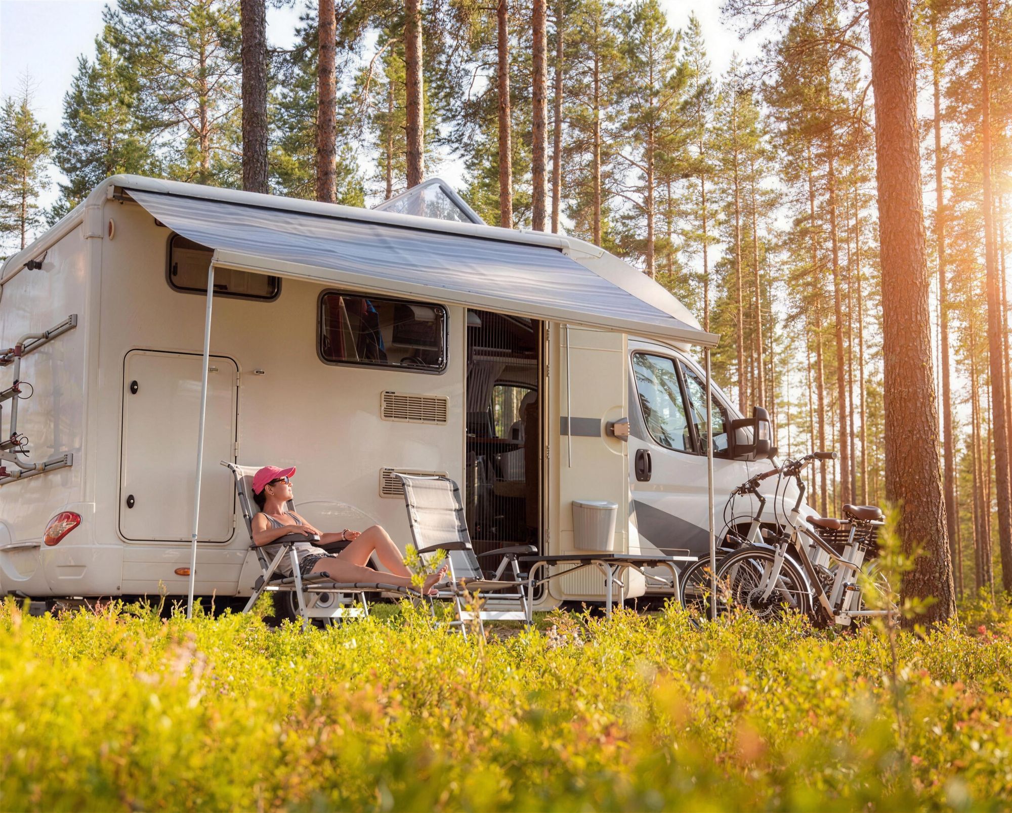 Camper met luifel op een rustige plek tussen de bomen